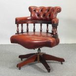 A red leather upholstered swivel desk chair