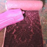 A roll of red velvet damask fabric