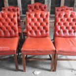 A set of ten red upholstered dining chairs