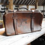 An early 20th century brown leather case, inscribed FK