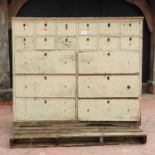 An early 20th century painted pine bank of drawers