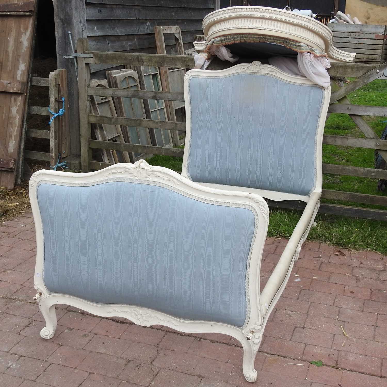 An early 20th century French style cream painted bed