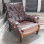 An early 20th century brown upholstered button back club armchair