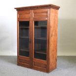 An early 20th century pitch pine glazed bookcase