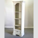 A modern cream painted narrow standing open bookcase