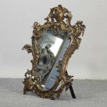 An ornate brass framed easel mirror
