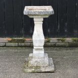 A reconstituted stone bird bath