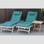 A pair of teak garden loungers