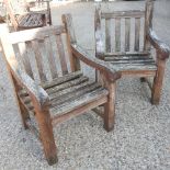 A pair of wooden garden armchairs