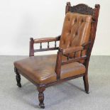 A Victorian carved and brown leather upholstered library armchair