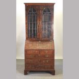 A George III style burr walnut bureau bookcase