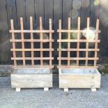 A pair of small wooden garden planters with trellis