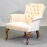 A 1920's cream upholstered button back armchair