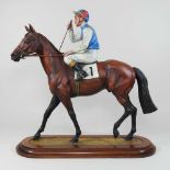 A large painted bronze model of a racehorse with jockey up
