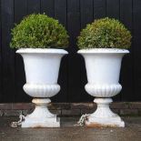 A pair of large white painted iron garden urns