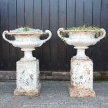 A pair of large white painted cast iron garden urns