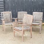 A near set of four teak garden armchairs