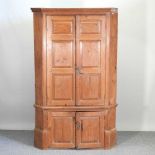 A 19th century pine standing corner cupboard