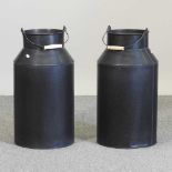 A pair of black painted metal milk churns