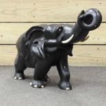 A carved ebonised model of an elephant