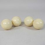 Four simulated ivory billiards balls