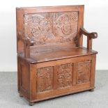 An early 20th century carved oak box settle