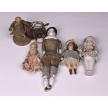 A collection of German bisque doll's house dolls, the first elaborately dressed in a pink satin