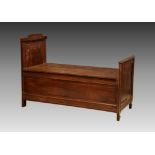 A walnut monk's bench, 1920s, the raised back to one end with floral and foliate carved panel,