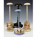 A pair of vintage doll head hat / wig stands, c.1930, one depicting a boy the other a girl, having