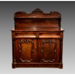A William IV mahogany chiffonier, the shaped back with carved foliate border and single shelf,