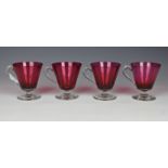 A set of four cranberry and clear glass custard cups, of tapering conical form with clear glass