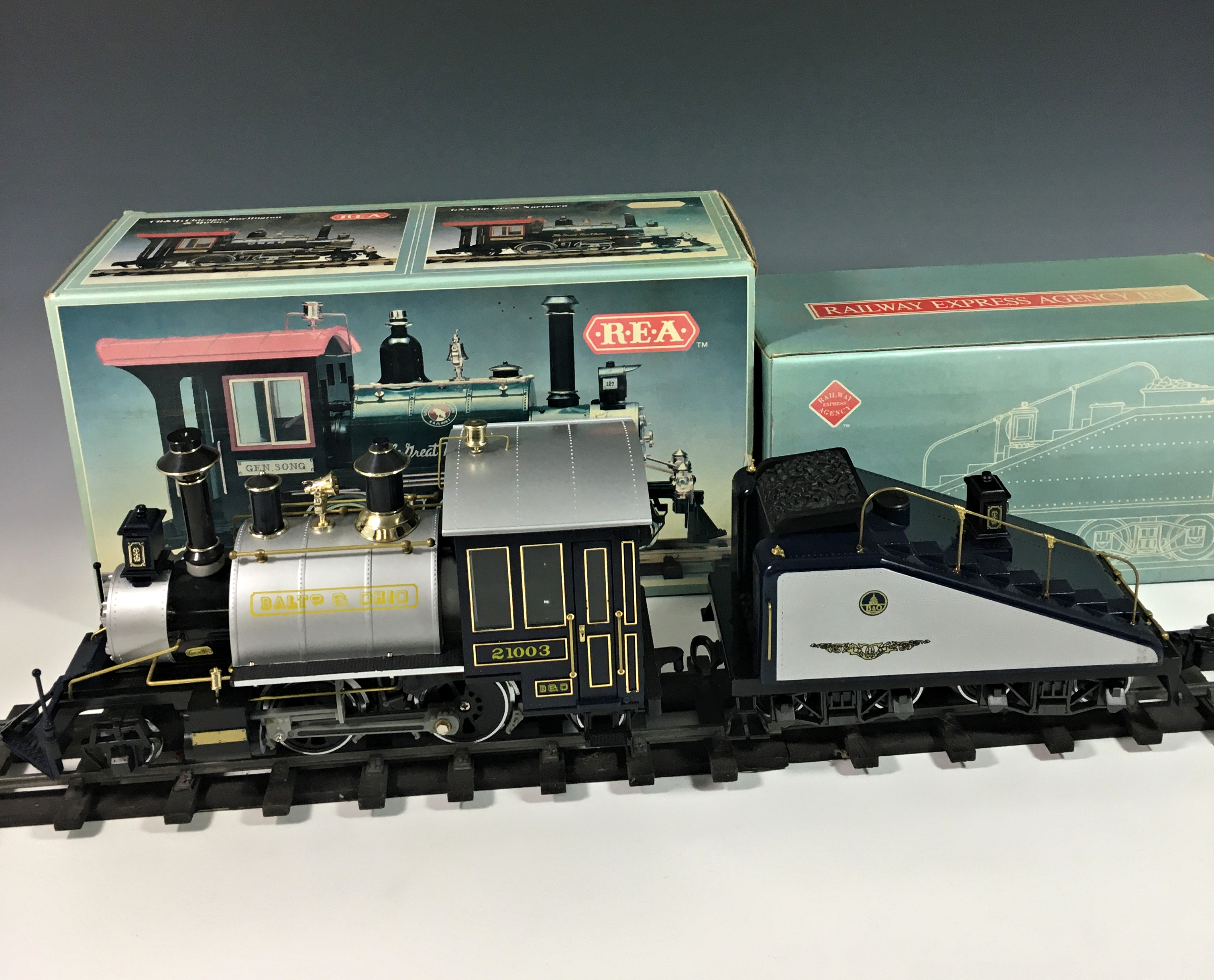 A boxed G scale REA B&O Rodgers steam locomotive and tender, REA-21003, with loose track.