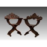 Two 19th century Continental carved walnut x-frame folding chairs, the shaped, carved backs over