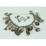 A silver charm bracelet with 15 charms attached, plus three loose charms.