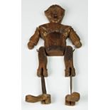 A antique carved wooden jig doll of rudimentary form, jointed with metal pins, (missing dowel),