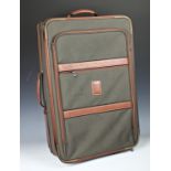 A Longchamp canvas suitcase with leather trim.