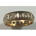 A pretty 9ct gold ribbed ring with central band of white stones around the whole circumference, size