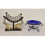 An unusual table centrepiece, depicting two African bull elephants beneath a metal weave basket with
