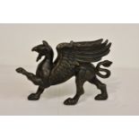 A modern Griffin cast iron door stop, painted in black, highlighted in gold, 13in. (33cm.) long.