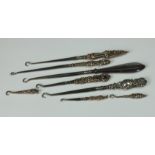 A collection of Victorian and later silver mounted button hooks by Adie & Lovekin Ltd, of varying