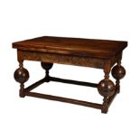 An Elizabethan style oak draw leaf dining table, the four plank top over a foliate arcaded frieze,