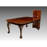 A 1920s mahogany wind-out extending dining table by Maple & Co., the top with rounded angles and