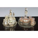 Two miniature dolls house glass drink sets, each having claret jug or decanters, glasses and trays