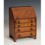 An antique George II style mahogany and boxwood inlaid miniature bureau, the fall front enclosing