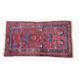 A Turkish rug, early to mid-20th century, the madder field with all over floral and vine