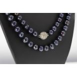 An opera length string of black pearls with CZ clasp, the pearls measuring approximately 9mm in