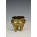 A Chinese polished bronze tripod censer, 19th / early 20th century, of squat cauldron form, raised