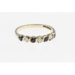 A 9ct gold, diamond and sapphire 7 stone ring, featuring 3 brilliant cut diamonds totalling