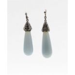 A pair of silver and chalcedony drop earrings, with pierced foliate detailing to the silver capped