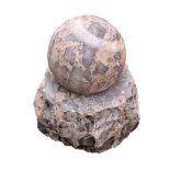 A small rotating sphere water feature, of composite stone construction with granite slivers,